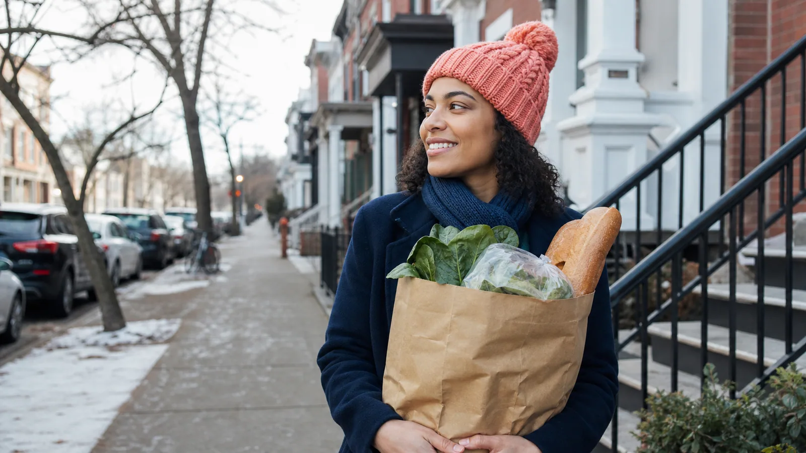 Person wearing a knit beanie while carrying groceries on a cold day
